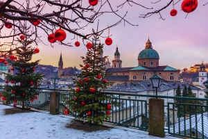 Winterlandschaft mit Weihnachtsbäumen und Kirche im Hintergrund.