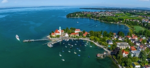 Luftaufnahme eines Hafens mit Segelbooten und umliegender Küstenlandschaft.