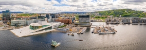 Panorama von Oslo mit Opernhaus und Hafen bei Wolkenhimmel.