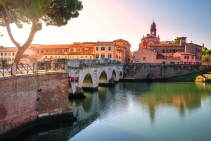 Historische Brücke über einen Fluss in einer italienischen Stadt bei Sonnenuntergang.