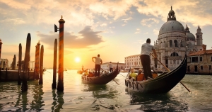 Gondeln fahren bei Sonnenuntergang vor Santa Maria della Salute in Venedig.