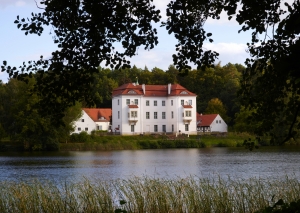 Jagdschloss Grunewald hinter einem See, umgeben von Bäumen.