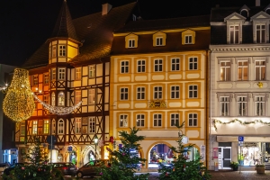 Beleuchtete Fachwerkhäuser bei Nacht mit Weihnachtsdekorationen.