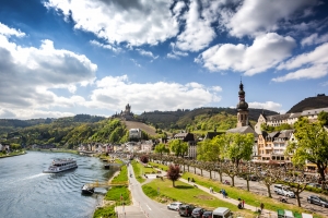 Stadtansicht am Fluss mit Schloss und Kirche im Hintergrund bei sonnigem Wetter