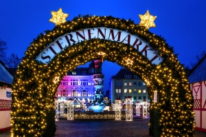Weihnachtsmarkt-Eingang bei Nacht mit Lichterdekoration.