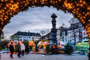 Weihnachtsmarkt mit beleuchtetem Bogen und Menschen davor