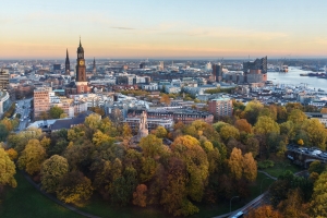 Stadtansicht von Hamburg mit Herbstbäumen und Elbphilharmonie im Hintergrund.