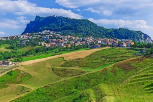Landschaft mit Hügeln, grünen Feldern und einer Stadt im Vordergrund