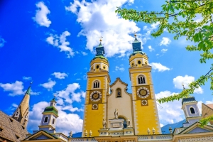 Barocke Kirche mit Doppeltürmen und blauem Himmel im Hintergrund.