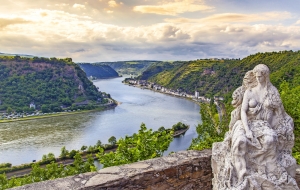 Statue einer Frau mit Blick auf den Rhein und grüne Hügel im Hintergrund