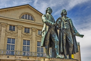 Statue zweier Männer vor einem historischen Gebäude.
