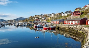 Hafen mit Fischerbooten und bunten Häusern im Hintergrund bei sonnigem Wetter